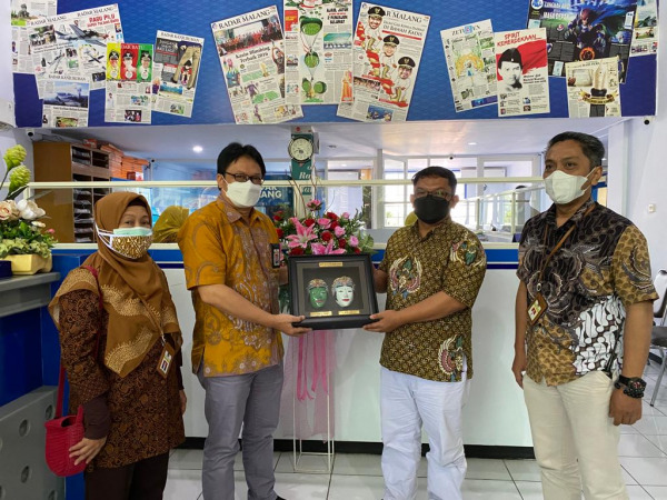 KUNJUNGAN: Kepala KPP Madya Malang Mochamad Na’im Amali (dua dari kiri) menyerahkan cendera mata kepada  Direktur Radar Malang Tauhid Wijaya (dua dari kanan), dalam kunjungannya ke kantor Jawa Pos Radar Malang, Jumat 14/01/2022). (Donvirgo/ Radar Malang)