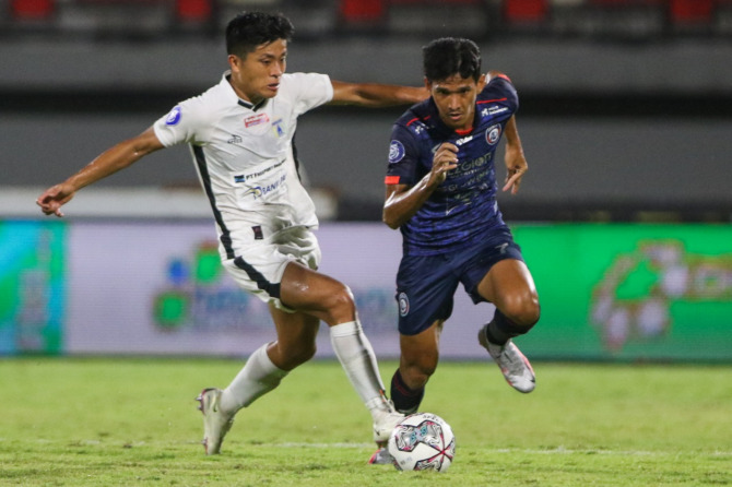 FLEKSIBEL: Ryan Kurnia (kanan) berjibaku dengan pemain Persipura Jayapura pada laga Jumat pekan lalu (28/1). Di tim Arema FC, dia dituntut mampu menjalankan tugas di luar posisinya. (Riana Setiawan / Jawa Pos)