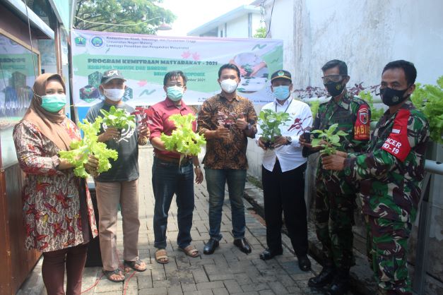DARI UM UNTUK MASYARAKAT: Tim Pengabdian Masyarakat Universitas Negeri Malang (UM) bersama Lurah Penanggungan Solikin SSos MSi  dihadiri oleh jajaran Koramil, tim pengabdian, warga serta PKK memperlihatkan hasil panen budidaya urban farming bertenaga sury