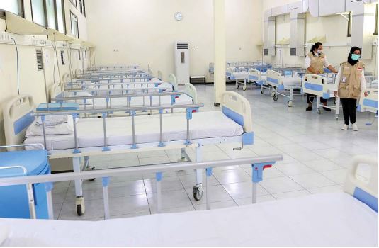 SIAP TERIMA PASIEN: Petugas RS Lapangan menyiapkan bed untuk menghadapi lonjakan pasien Covid-19 varian Omicron dalam pekan terakhir ini. Jumlah warga Kota Malang yang terpapar Covid menunjukkan peningkatan. (darmono/radar malang)