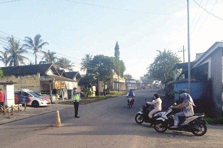 URAI MACET: Polantas dari Polres Malang mengatur arus lalu lintas (lalin) di simpang tiga Pakis, Kabupaten Malang, kemarin.