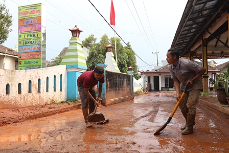 Dua warga Desa Srigading sedang membersihkan lumpur akibat banjir, sejak Selasa malam (8/3)