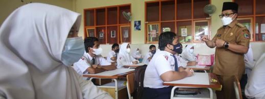 TETAP DIPANTAU: Wali Kota Malang Sutiaji (kanan) meninjau pembelajaran tatap muka (PTM) di SMP Negeri 8 Malang, kemarin (14/3). Sekolah itu langsung memasukkan seluruh siswanya.