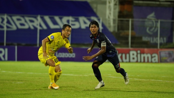 SEGERA UKIR REKOR: Johan Ahmat Farisi (kanan) berebut bola dengan gelandang Barito Putera Yu Hyun-koo beberapa waktu lalu. (Media Officer Arema FC For Radar Malang )