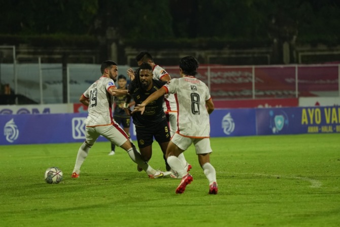 PILIH FOKUS KE LAGA: Carlos Fortes (tengah) dikepung pemain-pemain Borneo FC. Bila di laga nanti malam dia kena kartu kuning, Fortes bakal dilarang main melawan PSM Makassar. (Media Officer Arema FC For Radar Malang)