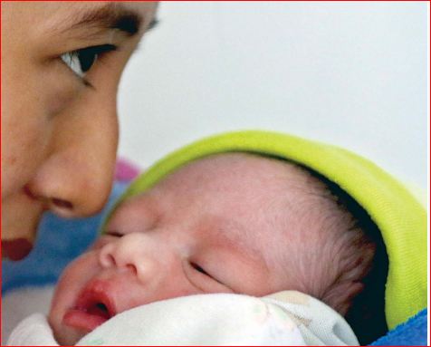 BANTU MENYUSUI: Nurul Muafidah menggendong bayi yang dibuang ke teras rumah milik Puspa Panda, warga Kelurahan Balearjosari, Kecamatan Blimbing, kemarin (6/3). (Darmono/Radar Malang)