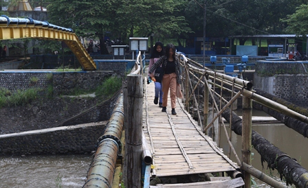 JEMBATAN DARURAT: Sambil menunggu perbaikan dari Pemprov Jatim, dam sekaligus jembatan Sengkaling ini dipasangi bambu. Hal itu dilakukan agar bisa dilintasi oleh warga.