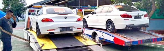 KEDOK INVESTASI: Foto atas, dua mobil BMW yang jadi barang bukti ikut dilimpahkan ke Kejari Kota Malang dan langsung dikirim ke Rumah Penyimpanan Benda Sitaan Negara Pasuruan. (KEJARI KOTA MALANG FOR RADAR MALANG)