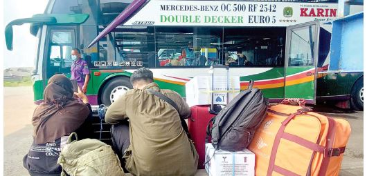 WAJIB JAGA KONDISI: Dua pemudik menunggu pemberangkatan bus di Terminal Arjosari kemarin (28/4). (SUHARTO/RADAR MALANG)