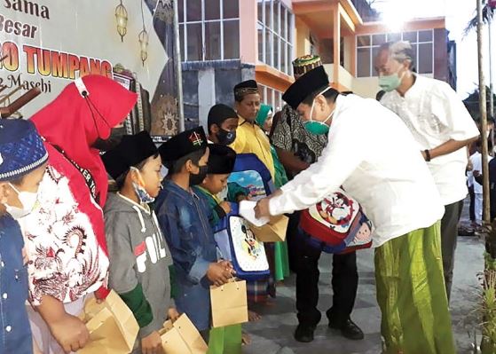 SEDEKAH RAMADAN: Komisaris PT Anugerah Citra Abadi (ACA) Iwan Kurniawan (kanan) menyerahkan santunan kepada anak yatim piatu dan duafa di Desa Banjarejo, Kecamatan Ngantang, kemarin (25/4). Santunan rutin tahunan ini berlangsung sebulan penuh selama Ramad