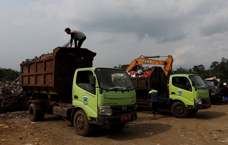 BUANGLAH SAMPAH PADA TEMPATNYA: Petugas dari DLH Kabupaten Malang menurunkan sampah di TPA Talangagung, Kecamatan Kepanjen, kemarin (17/5). Kurang dari separo sampah di Bumi Kanjuruhan yang sampai di TPA. Sisanya dibuang ke sungai oleh warga.