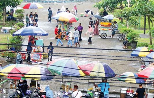 AJI MUMPUNG: Para pedagang kaki lima berjualan hampir di seluruh sudut Alun-Alun Kota Malang memanfaatkan momentum libur Lebaran, kemarin. (DARMONO/RADAR MALANG)