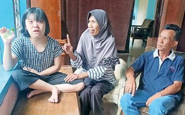 TETAP BERSYUKUR: Pasangan Yuniati dan Bambang Nuryadi sangat telaten membesarkan putrinya yang berkebutuhan khusus. (SUHARTO/RADAR MALANG)