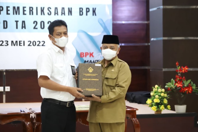 LAPORAN KEUANGAN: Ketua BPKP Jatmi Joko Agus Setiono menyerahkan LHP Opini WTP kepada Bupati Malang Sanusi, kemarin.