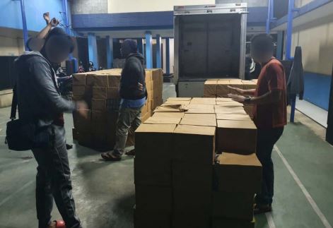 TAK BERCUKAI: Petugas Bea Cukai saat mengecek puluhan kardus rokok usai diturunkan dari truk di Jalan Ki Ageng Gribig, Kedungkandang, Jumat dini hari kemarin. Akibat usaha ilegal, negara dirugikan Rp 324,8 juta. (BEA CUKAI FOR RADAR MALANG)