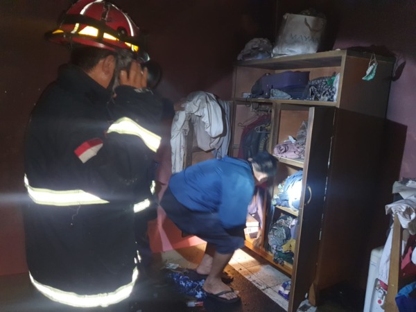 PEMADAMAN: Petugas PMK Kota Malang sedang melakukan pembasahan titik api di rumah kos milik Didik Suhartono, Jalan Bendungan Sutami, Kelurahan Sumbersari, Kecamatan Lowokwaru, Selasa malam (3/ 5). (YUDHISTIRA/RADAR MALANG)