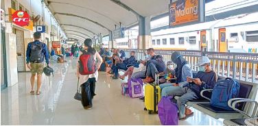 SUDAH ADA PERGERAKAN: Para calon penumpang kereta api jarak jauh menunggu jadwal keberangkatan di peron Stasiun Malang kemarin. (YUDHISTIRA/RADAR MALANG)