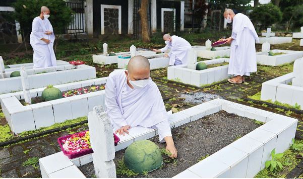 TETAP JAGA PROKES: Sejumlah umat Buddha di Kota Batu melakukan sesi tabur bunga di taman makam pahlawan (TMP) Kelurahan Ngaglik, Kecamatan Batu, Kota Batu kemarin (15/5). Sebelumnya, prosesi itu tak bisa dijalani akibat pandemi. (DARMONO/RADAR MALANG)