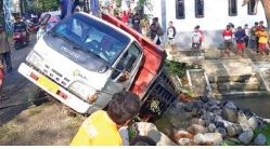 AMBLES: Truk bermuatan batu fondasi terperosok saat melintasi jembatan tua di Jalan Krajan Senggreng, Desa Sambigede, Kecamatan Sumberpucung, Minggu (22/5). (HANIFUDDIN MUSA/ RADAR MALANG)