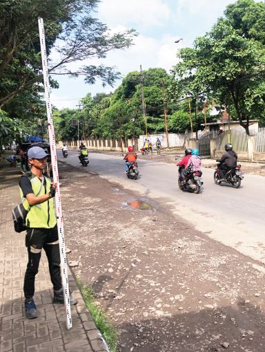 DIUKUR DULU: Salah seorang pekerja kontraktor pemenang lelang mengukur jalan KrebetGondanglegi yang segera diperbaiki.(YUDISTIRA/RADAR MALANG)