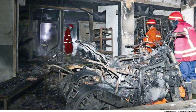 MAYORITAS AKIBAT KORSLETING: Petugas pemadam kebakaran berusaha menjinakkan api yang melalap rumah di Jalan Kenangan, Jatimulyo, 29 Mei lalu. (DARMONO/RADAR MALANG)