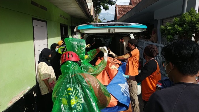 SUDAH MEMBUSUK: Relawan Malang Raya mengevakuasi jenazah Sugeng Edi Santoso yang ditemukan meninggal di rumahnya, Jalan Mergan Sekolahan Kelurahan Tanjungrejo, Kecamatan Sukun kemarin pagi (10/6). (RELAWAN MALANG RAYA FOR RADAR MALANG)