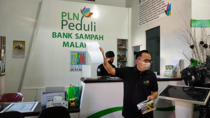 RUJUKAN DAERAH LAIN: Salah satu pendiri Bank Sampah Malang (BSM) Rahmat Hidayat menunjukkan buku rekening nasabah kepada ibu-ibu dari daerah lain saat studi banding di Malang, tadi siang (28/6)
