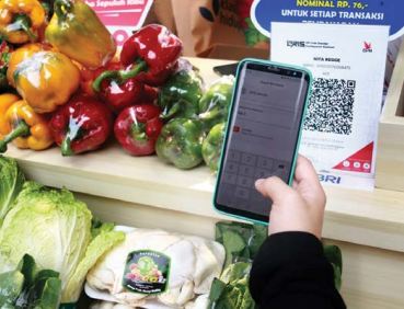 INOVASI TANPA HENTI: Salah satu warga melakukan transaksi dengan melakukan scan pada barcode yang ada di QRIS BRI belum lama ini.(BRI FOR RADAR MALANG)