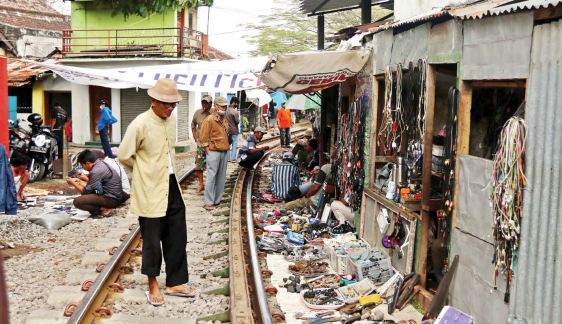 BERBAHAYA: Sejumlah penghuni bangunan liar di dekat rel kereta api Jagalan juga memanfaatkan kawasan itu untuk berdagang. Rel itu masih aktif digunakan sebagai jalur kereta api bahan bakar minyak.(DARMONO/RADAR MALANG)