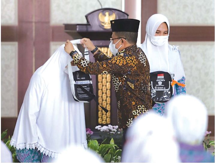 PERJALANAN SUCI: Wali Kota Batu Punjul Santoso mengalungkan name tag kepada jamaah calon haji sebagai tanda pemberangkatan, Selasa (14/6).(ALIFIANI/RADAR BATU)