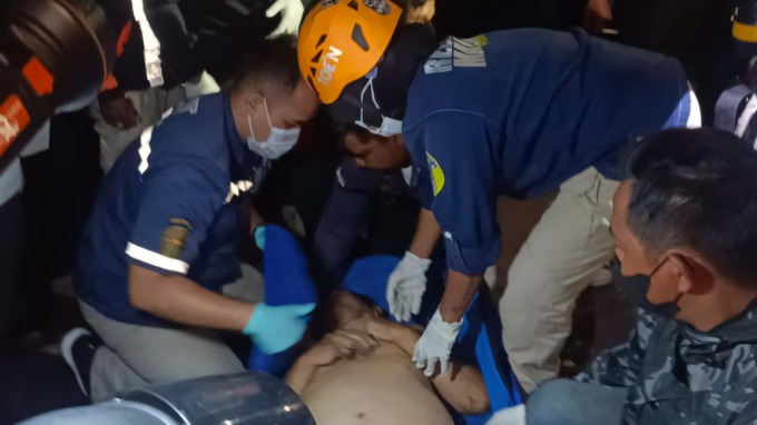 EVAKUASI: Petugas bersama warga sedang mengevakuasi jenazah berjenis kelamin pria yang ditemukan mengambang dekat jembatan taman wisata rakyat (Tawira), Kiduldalem, Kecamatan Klojen. (SUHARTO/RADAR MALANG)