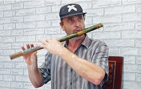 BUNUH RASA BOSAN: Martin Stephen memainkan seruling buatannya sendiri di dalam Lapas Lowokwaru, kemarin. (BIYAN MUDZAKY HANINDITO/RADAR MALANG)