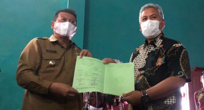 PRIORITAS: Wakil Bupati Malang Didik Gatot Subroto menyerahkan sertifikat PTSL kepada Sumei Adi, warga Desa Tanggung Kecamatan Turen, kemarin.(YUDISTIRA/RADAR KANJURUHAN)