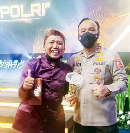 MENANG: Suharto (kiri) menerima penghargaan yang diserahkan oleh Kadiv Humas Polri Irjen Pol Dedi Prasetyo di Gedung Tribrata, Jaksel, Rabu malam (22/6).(humas polri for radar malang)