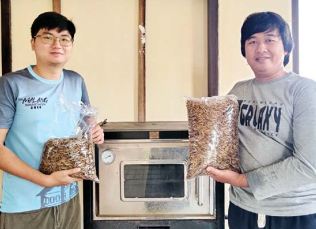 BISNIS MENJANJIKAN: Dwiki Muhangka (kanan) dan Anthony Widyanto menunjukkan produk maggot kering yang dilirik banyak industri makanan.(NABILA AMELIA/RADAR MALANG)