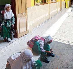 KALAH BERSAING: Beberapa pelajar di MI Tarbiyatul Huda hendak pulang ke rumah. Gedung sekolah itu jadi satu dengan SMP Tarbiyatul Huda.
