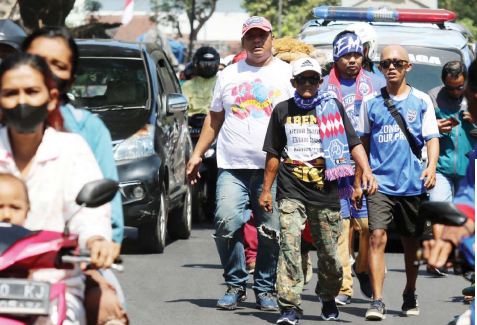 SAKING CINTA AREMA: Joko Wicaksono (depan) didampingi sejumlah teman melangkahkan kaki dari Stadion Kanjuruhan menuju kantor Arema di Jalan Mayjen Panjaitan, Kota Malang, kemarin. Ini dilakukan karena dia bernazar setelah Arema juara Piala Presiden 2022.