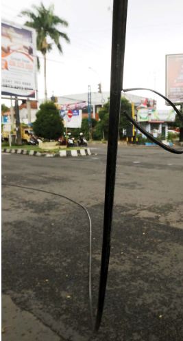 HATI-HATI: Kabel yang terserempet bus itu menjuntai ke ruas jalan di simpang empat Jalan Raya Dieng, kemarin (14/7). Pengendara harus berhati-hati agar tidak terjerat kabel.