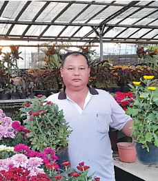 HARGATURUN: Salah satu pedagang bunga krisan di Mall Bunga Sidomulyo menunjukkan koleksi bunga di kiosnya, Selasa (5/7).(AFIFAH RAHMATIKA/RADAR BATU)