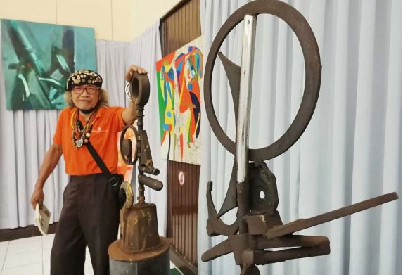 BUAH TANGAN KREATIF: Ono Gaf, salah satu seniman senior sedang menunjukkan karya seninya berbahan besi bekas dalam pameran di ITN, kemarin.