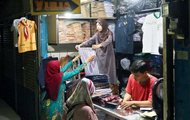 PERMINTAAN MENINGKAT: Penjualan seragam sekolah di Pasar Besar Malang meningkat selama sepekan terakhir.