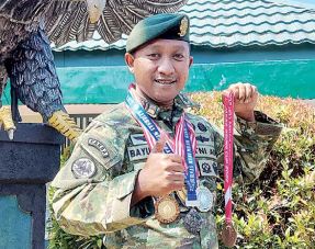 PASSION MENEMBAK: Lettu Arh Bayu Sekti Wicaksono menunjukkan sebagian medali yang dia ukir dari salah satu kejuaraan lomba menembak reaksi.(BIYAN MUDZAKY HANINDITO/ RADAR MALANG )
