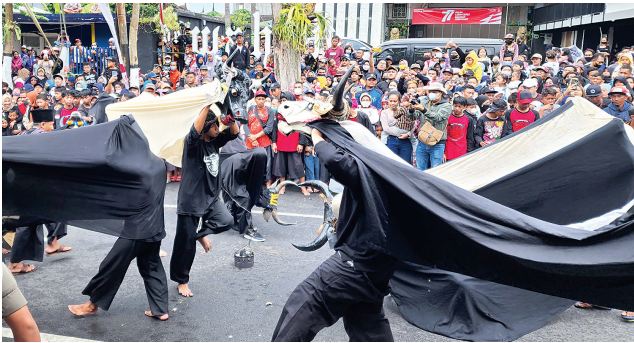 SEMPAT VAKUM: Salah satu tim peserta kirab 1.000 bantengan melakukan aksi di depan warga, kemarin siang (7/8). Rutenya dari Jalan Gajahmada-Jalan Panglima Sudirman.