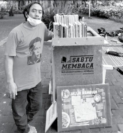 MANFAATKAN HARI KELUARGA: Hari Pendek rutin membawa buku-bukunya ke Taman Slamet setiap Sabtu pagi agar bisa dibaca setiap orang secara gratis. (MITA BERLIANA/RADAR MALANG)