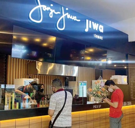 JAMINAN KUALITAS: Dua orang pengunjung bertransaksi di outlet Janji Jiwa MOG, kemarin. (Binti N. Rosidah/Radar Malang)