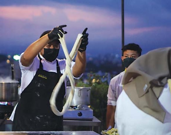Manjakan Lidah: Chef andal menyajikan menu spesial dalam program atap Senja di rooftop maxone ascent hotel, kemarin. (Amel/Radar Malang)