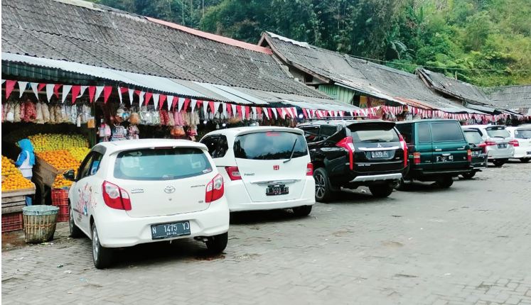 RAMAI: Deretan kendaraan pengunjung memadati areal parkir Dewi Sri di Kecamatan Pujon, Kabupaten Malang, kemarin (14/8).