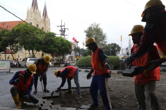 INFRASTRUKTUR: Para pekerja membongkar batu andesit di zona tiga Kajoetangan Heritage, kemarin (29/8). Setelah dibongkar, DPUPRPKP Kota Malang akan memasang lagi dengan batu yang masih bagus. (DARMONO/RADAR MALANG)