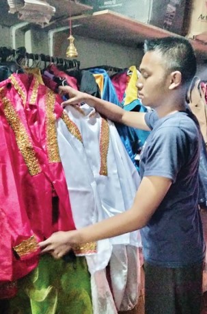 SUDAH DIORDER: Okan Abdilah menyiapkan beragam kostum untuk karnaval Agustusan yang sudah disewa pelanggan. (Nabila Amelia/Radar Malang)