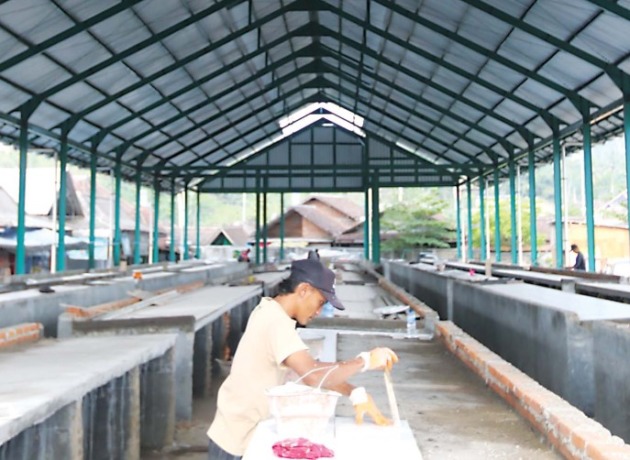PERSIAPAN PINDAHAN: Pekerja sedang memasang keramik untuk lapak di Pasar Kedungkandang, kemarin (12/8). (Darmono/Radar Malang)
